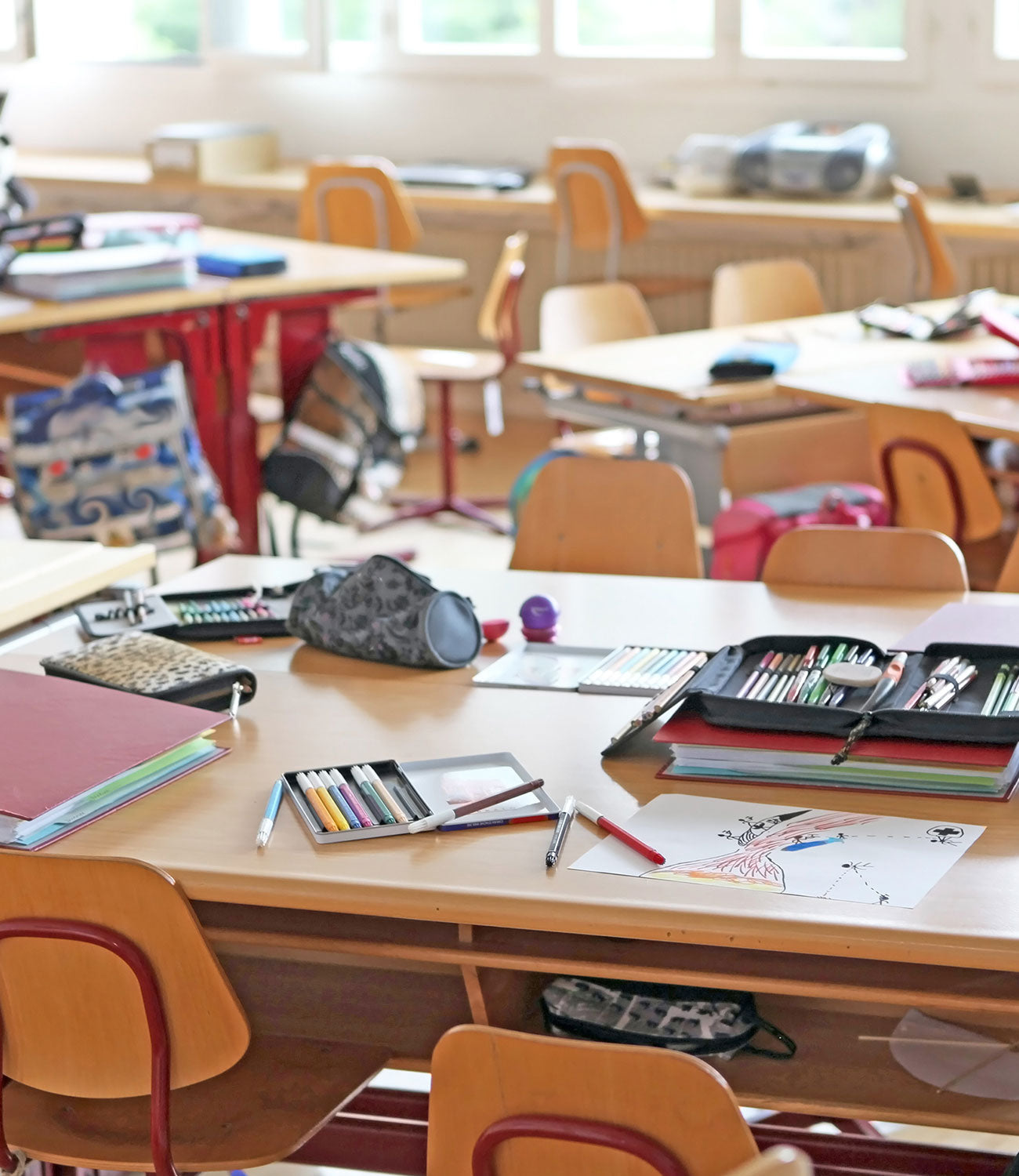 Leeres Klassenzimmer mit Tischen und Stühlen, bereit für den Unterricht.