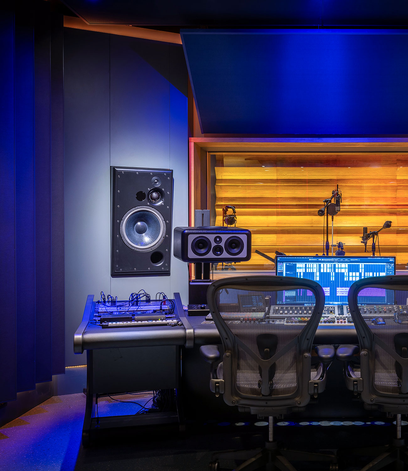 Ein Aufnahmestudio mit einem Mischpult, Lautsprechern und einem Computer.