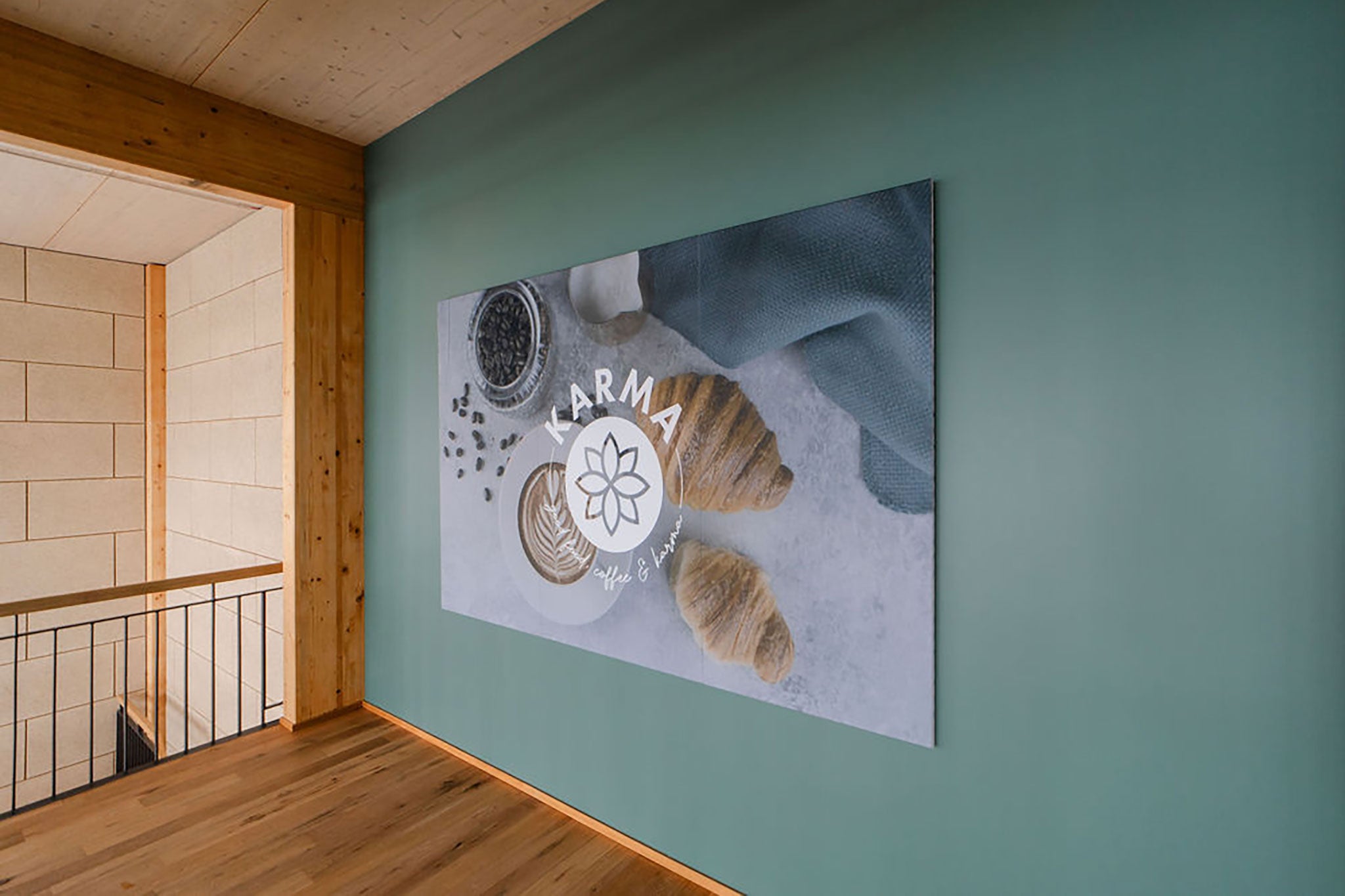Schallabsorbierendes Wandbild an einer grünblauen Wand aufgehängt.