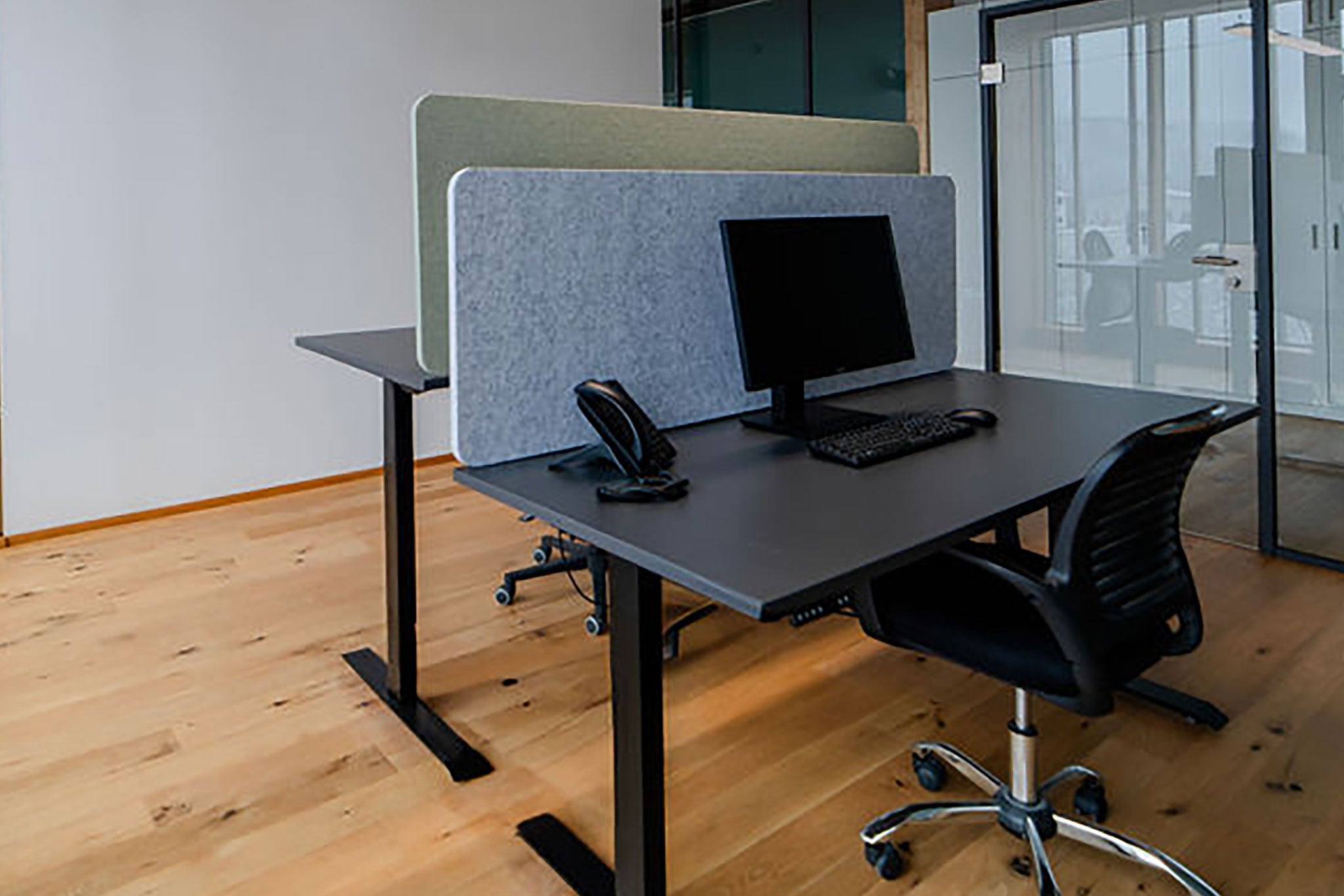 Bürotische abgetrennt mit Tischtrennwänden, die für eine produktive Arbeitsumgebung sorgen.