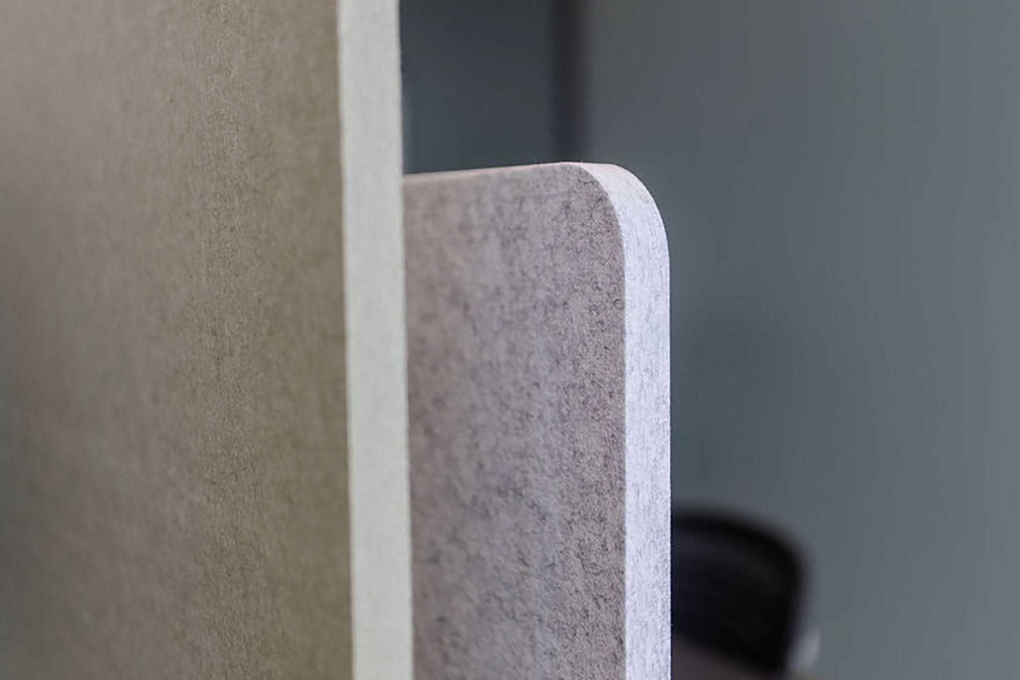 Nahaufnahme einer grauen Tischtrennwand, die die Textur und Farbe des Materials zeigt.